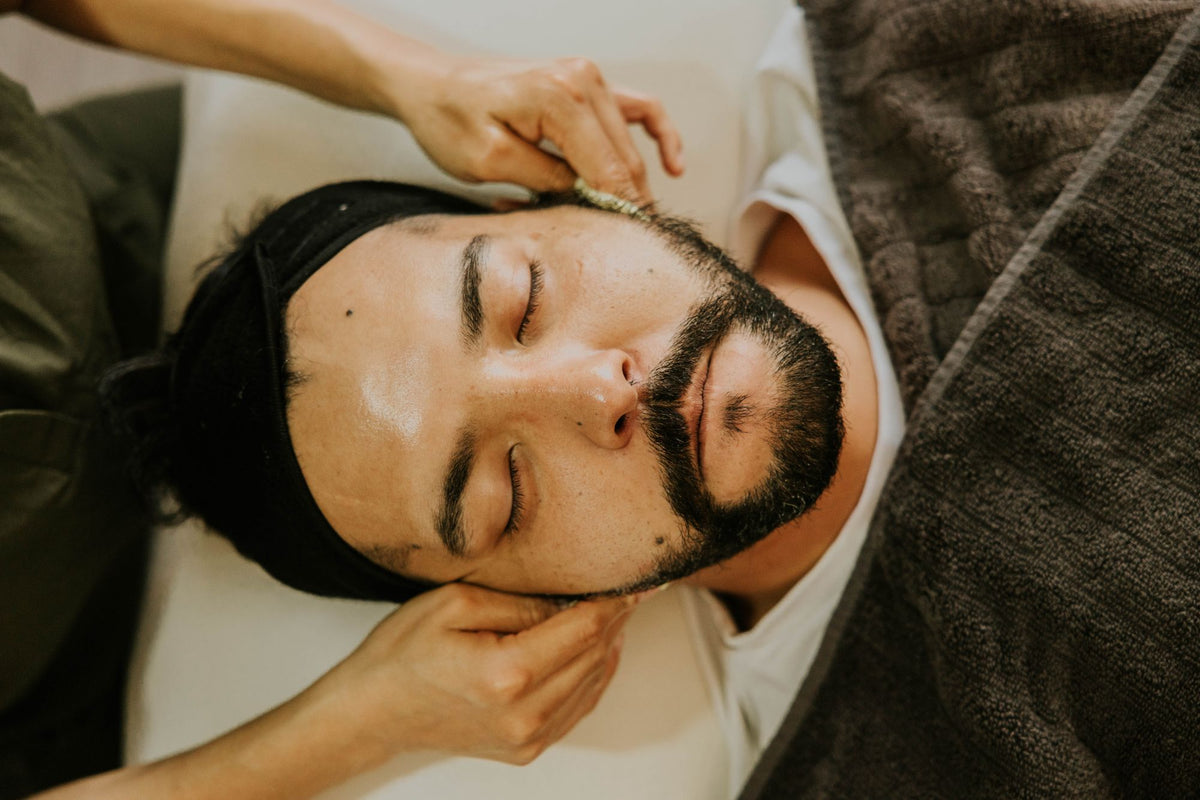 Homme recevant un soin du visage en cabine