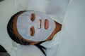 Masque en feuille posé pendant un soin du visage