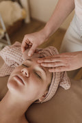 Mains posées sur le front pendant un soin du visage