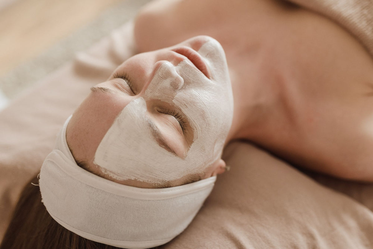 Masque crème hydratant posé sur le visage, cliente détendue