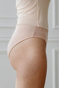 Silhouette de profil en lingerie nude, peau lisse